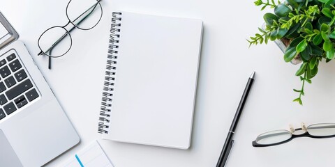 Top view of a blank white notebook on desk with, copy space. modern workplace with blank notebook, laptop, coffee cup and other items. Mock up