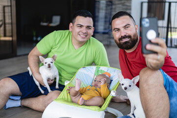 Happy male LGBT couple taking a selfie with their son and pet