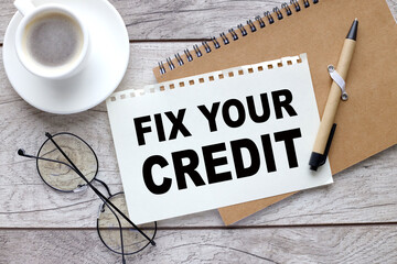 FIX YOUR CREDIT sheet of paper with text near a cup of coffee