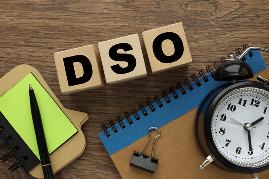DSO table clock and wooden cubes on the work table. text on wooden blocks