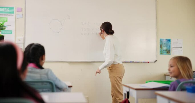 Woman, math and writing on whiteboard in classroom for learning, development and students growth. Teacher, curriculum and children in kindergarten or elementary school for knowledge, study and test