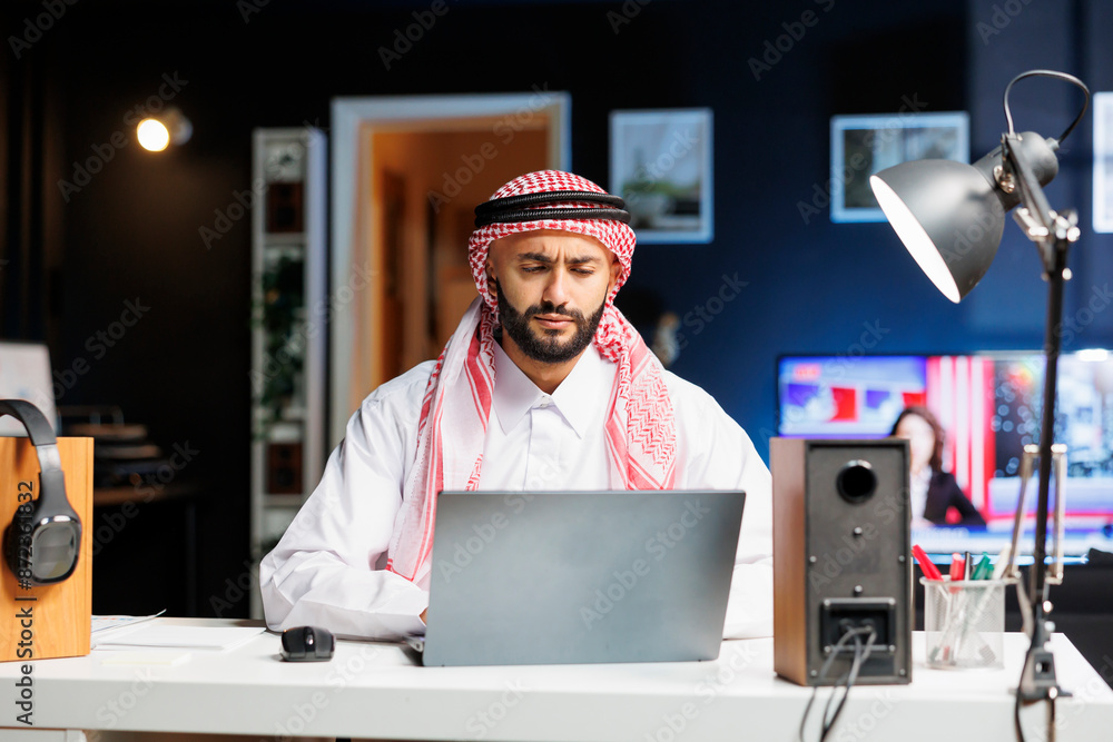 Aufkleber smiling youthful man dressed in islamic attire efficiently working on his wireless computer. he brow