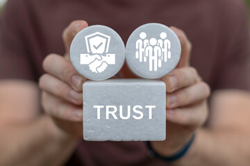 Man holding white blocks sees word: TRUST. Trust and Partnership Business Finance Web Technology Concept. Trusted partner.