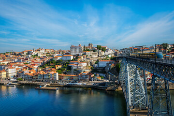 Obraz premium View of Porto city and Douro river and Dom Luis bridge I with metro tram from famous tourist viewpoint Miradouro do Jardim do Morro. Porto, Vila Nova de Gaia, Portugal