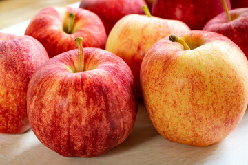 Gala apples on a white cutting board.