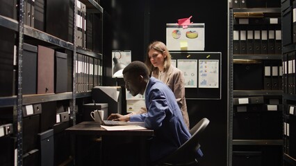 Police officers conduct thorough investigations and review evidence files in incident room....