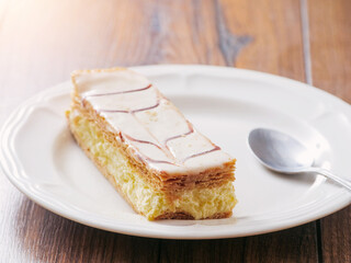 Plate with portion of cram cake on wooden table. Bakery fine product and dessert.