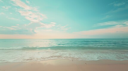 Obraz premium A serene scene of calm ocean waves gently washing up on a sandy beach, under a soft sunset sky. The tranquil color palette creates a peaceful and relaxing atmosphere.