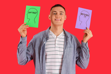 Young man with reminders on red background