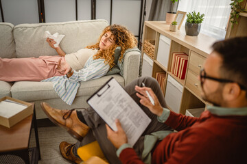 Psychotherapist listen to cry woman client and writes in clipboard