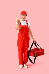 Female Asian courier with doner kebab and bag on pink background