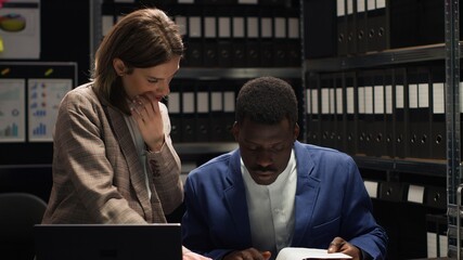 African American and Caucasian law enforcement officers collaborate to solve confidential crime...