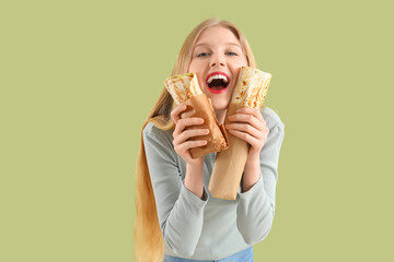 Young woman with doner kebabs on green background