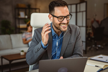 man listen music while work from home and girlfriend in the background