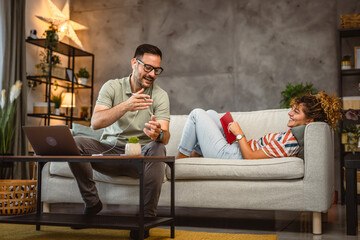 Obraz premium Boyfriend and girlfriend talk while he make break from work on laptop at home