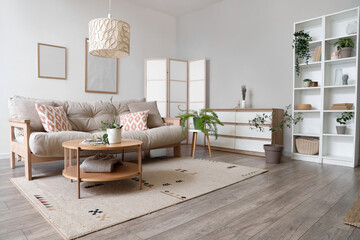 Interior of living room with sofa, commode and folding screen