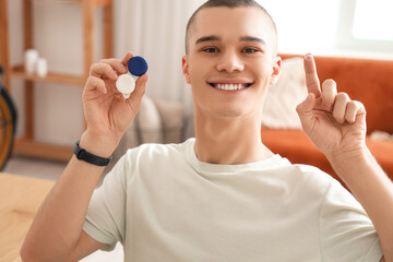 Young man with contact lenses at home, closeup