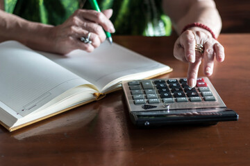 Photo of unrecognizable senior woman doing finances at home