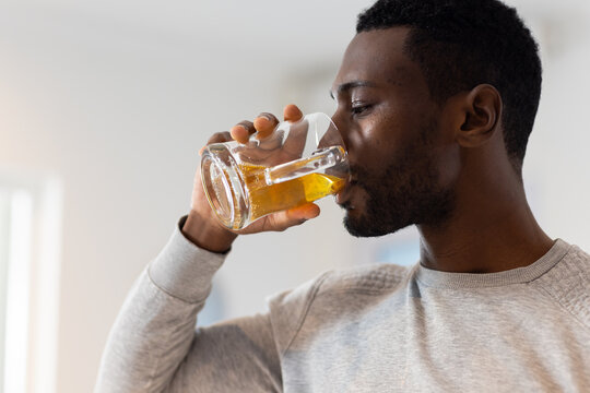 Drinking beer, man enjoying alcohol beverage at home