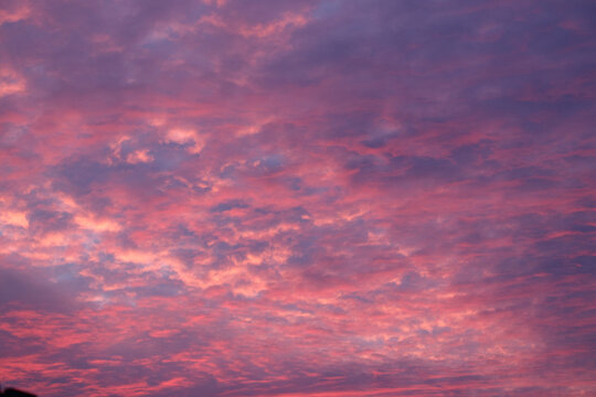 Stunning sky filled with vibrant pink and purple clouds at sunset, creating a dramatic and colorful backdrop.