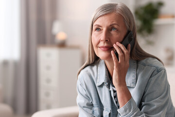 Senior woman talking on phone at home, space for text