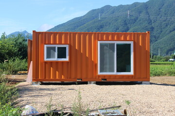 Orange shipping container near the mountains