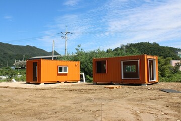 Orange shipping container offices near construction site