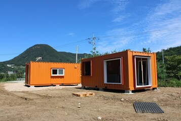 Orange shipping container offices near construction site