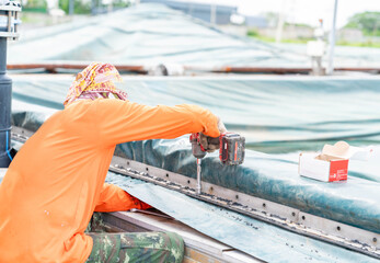 Worker use cordless wrench tighten nut of gasket edge treatment pond.