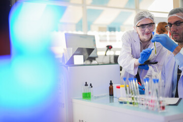scientists perform experiments and record data. people arranges equipment with test tubes and chemicals for producing medicine and biochemistry. man hold tubes of chemical liquids and plant samples.