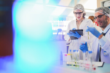 scientists perform experiments and record data. people arranges equipment with test tubes and chemicals for producing medicine and biochemistry. man hold tubes of chemical liquids and plant samples.