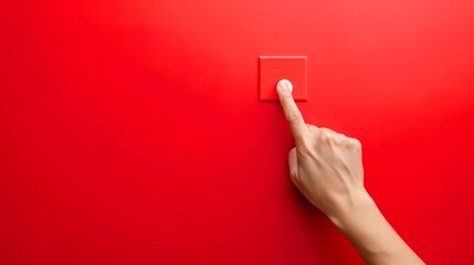 Hand pressing red button on red background