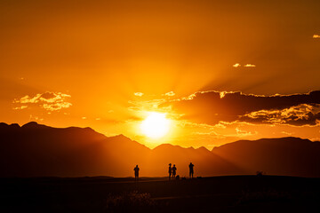 Fototapeta premium silhouette of a group of people during a sunset at white sand national park