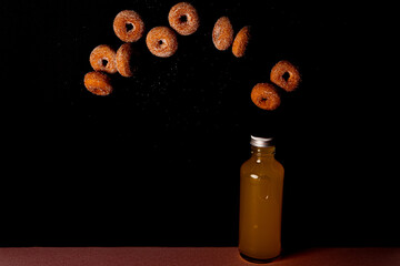 瓶に入ったオレンジジュースと宙を飛ぶ小さなドーナツ