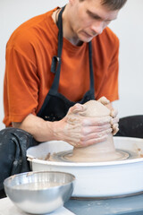 A potter working on a potter's wheel. Vertical photo.