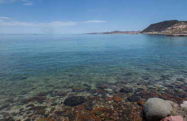 View of La Paz Bay on rocky beach with mountains in the background and blue sky on summer vacation, Copy space with blue sky panoramic nature photography