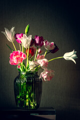 Still life with bouquet of summer flowers. Tulip flowers in a vase on the table.