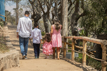 Siblings mother father grand parent Family members holding hands while walking in a park during a sunny day in Lima Peru