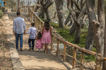 Siblings mother father grand parent Family members holding hands while walking in a park during a sunny day in Lima Peru