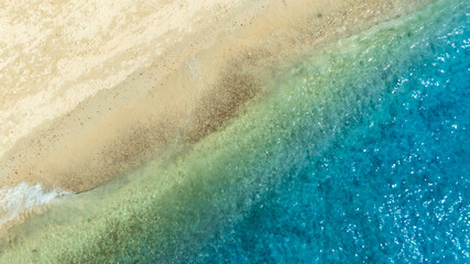 Top view nature of the beach and sea Summer with sunshine sandy beaches, clear blue waters sparkling against the blue sky. on an island with good ecology and environment Background for summer vacation