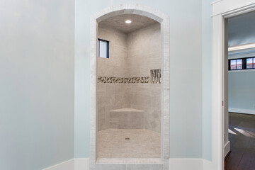 Custom Curved Shower Design With Stone Tiling And Natural Light Window