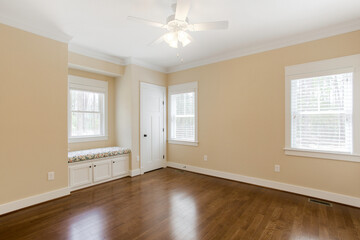 Large Bedroom With Hardwood Flooring, Ceiling Fan, And Window Seat