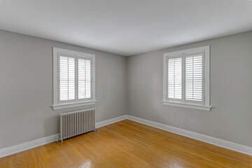 Empty Room With Hardwood Flooring And White Walls Featuring Two Windows