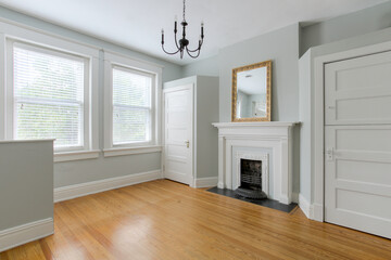 Beautiful Living Area With Wooden Floor, Fireplace, Mirror, And Chandelier