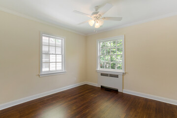 Calm Empty Room With Hardwood Floor, White Walls, Windows, And Ceiling Fan