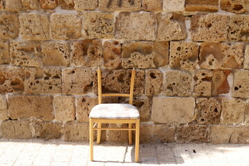 A lounge chair stands on the sidewalk on a street in a big city.