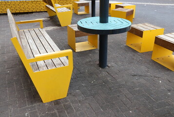 A lounge chair stands on the sidewalk on a street in a big city.