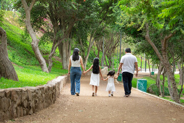 Siblings mother father grand parent Family members holding hands while walking in a park during a sunny day in Lima Peru