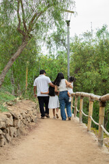 Siblings mother father grand parent Family members holding hands while walking in a park during a sunny day in Lima Peru