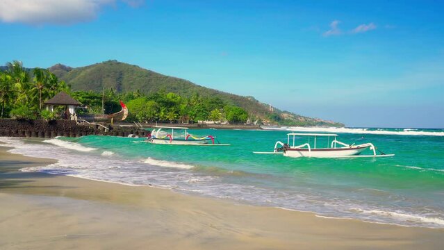 Tropical beach Bali with scenery traditional wooden boat in crystal clear ocean on nature background Bali Indonesia 4K
